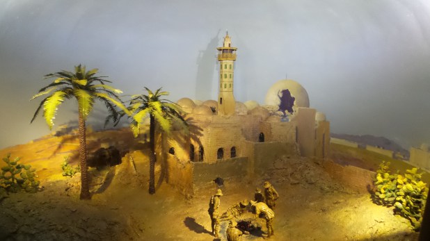 The long trek ends The diorama depicts a handful of light horsemen preparing a meal in the shadow of a battle-scarred mosque. Their mounts are tethered under a clump of palms in the background.
